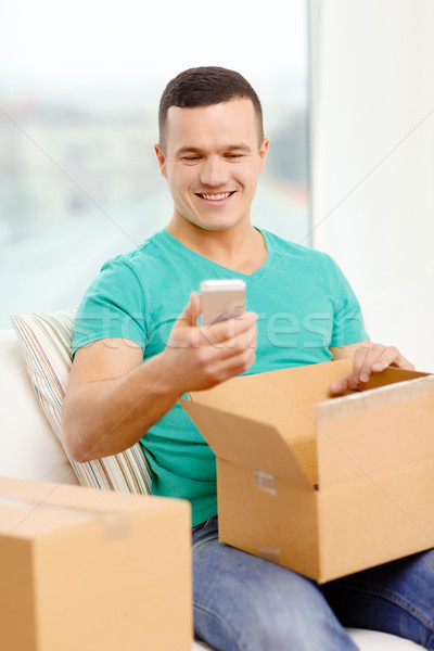 opening cardboard box and taking out smartphone Stock photo © dolgachov