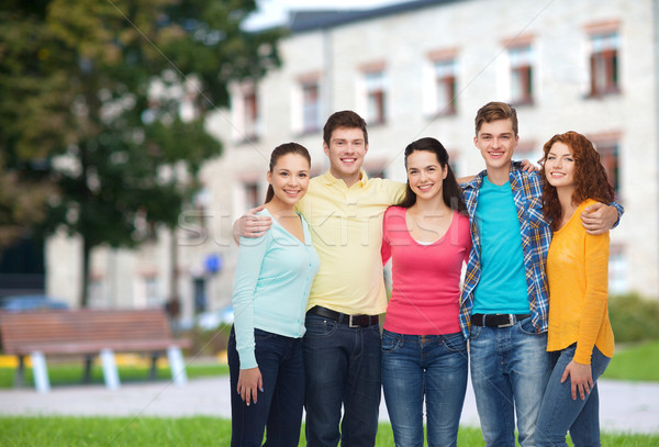 group of smiling teenagers over campus background Stock photo © dolgachov