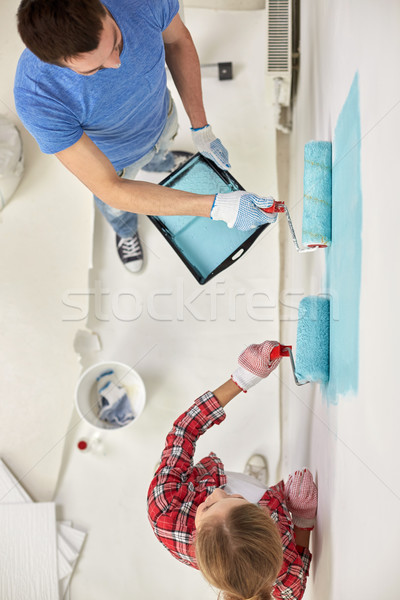 couple with paint rollers painting wall at home Stock photo © dolgachov