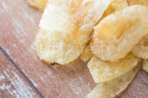 close up of crunchy potato crisps on wooden table Stock photo © dolgachov