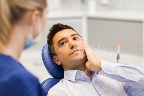 female dentist and male patient with toothache Stock photo © dolgachov