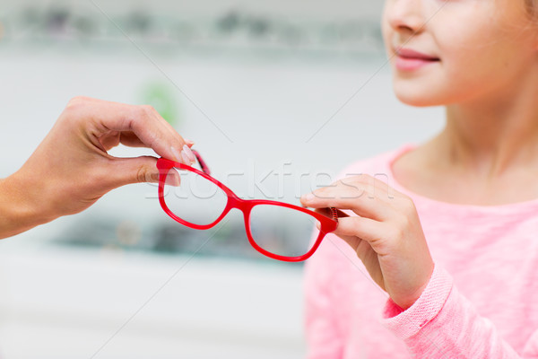 close up of girl taking glasses at optics store Stock photo © dolgachov