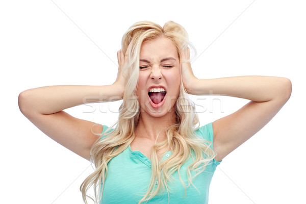 Stock photo: young woman holding to her head and screaming