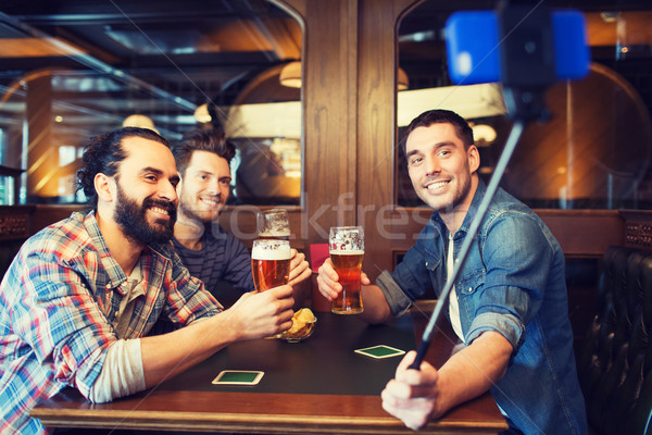 friends taking selfie and drinking beer at bar Stock photo © dolgachov