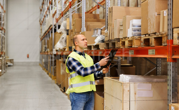man with clipboard in safety vest at warehouse Stock photo © dolgachov