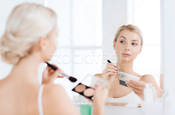 woman with makeup brush and foundation at bathroom Stock photo © dolgachov