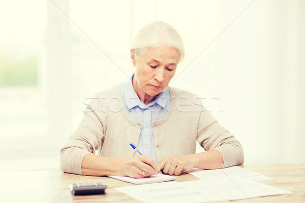 senior woman with papers and calculator at home Stock photo © dolgachov