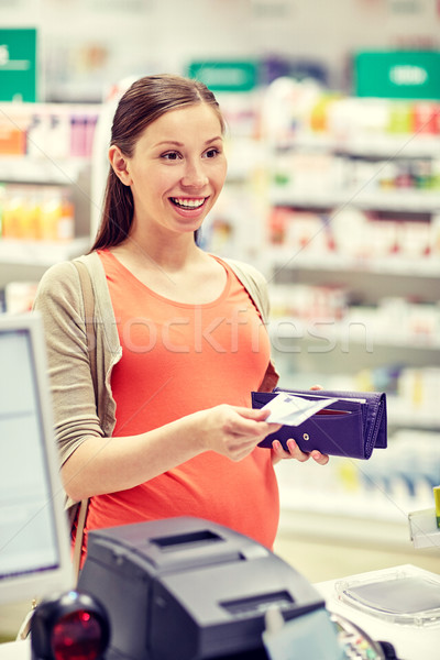 pregnant woman with wallet at cashbox in drugstore Stock photo © dolgachov
