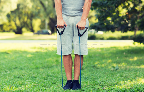 young man exercising with expander in summer park Stock photo © dolgachov