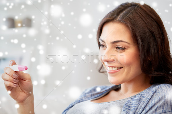 happy woman looking at home pregnancy test Stock photo © dolgachov