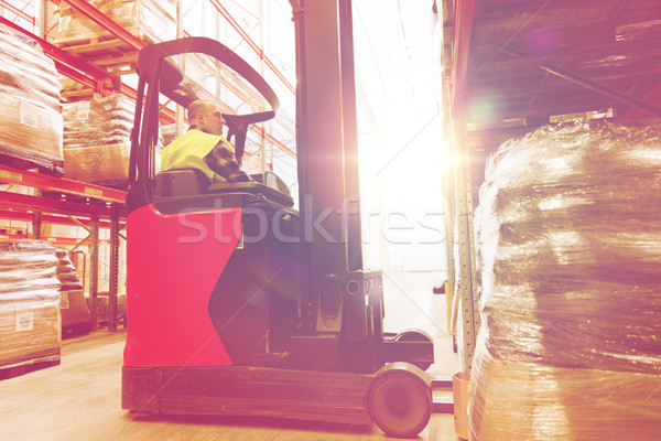 man on forklift loading cargo at warehouse Stock photo © dolgachov
