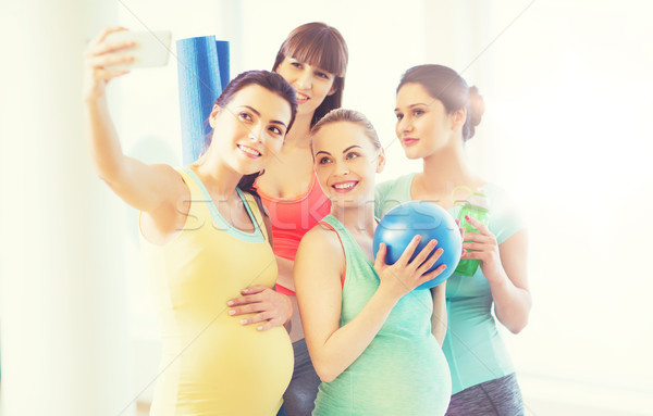 pregnant women taking selfie by smartphone in gym Stock photo © dolgachov