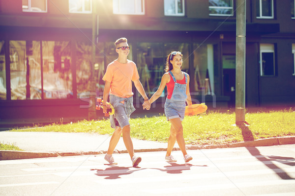 teenage couple with skateboards on city street Stock photo © dolgachov