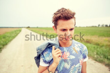 sad young hippie man walking along country road Stock photo © dolgachov
