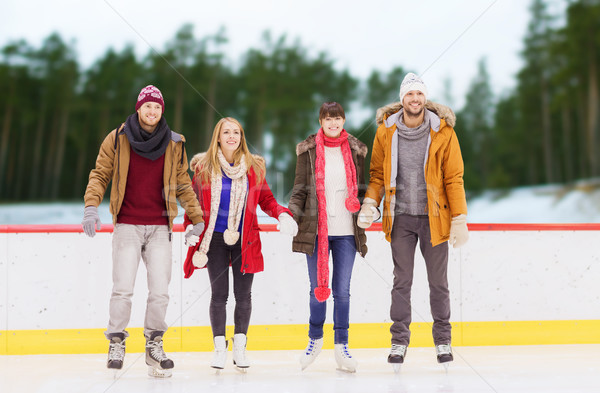 friends holding hands on outdoor skating rink Stock photo © dolgachov