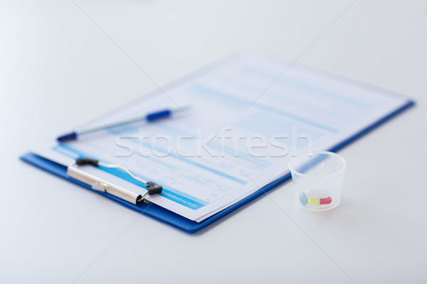 clipboard with report and drugs in medical cup Stock photo © dolgachov