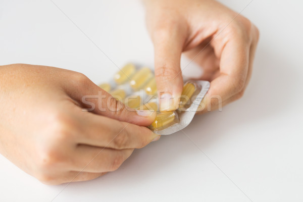 woman hands opening pack of medicine capsules Stock photo © dolgachov