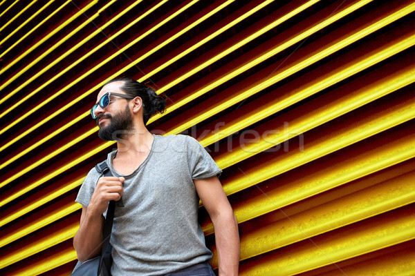 Adam güneş gözlüğü çanta ayakta sokak duvar Stok fotoğraf © dolgachov
