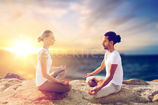 happy couple making yoga and meditating outdoors Stock photo © dolgachov