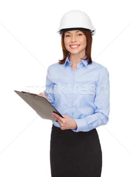 Sorridente empresária capacete clipboard edifício em desenvolvimento Foto stock © dolgachov