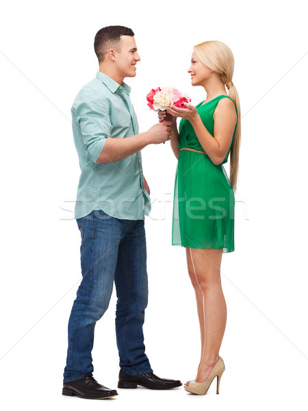 smiling couple with flower bouquet Stock photo © dolgachov