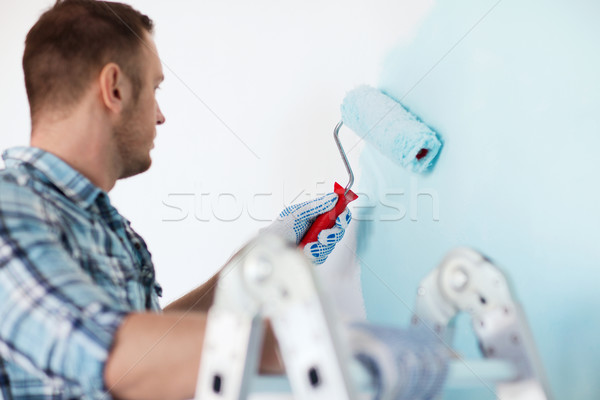 close up of male in gloves holding painting roller Stock photo © dolgachov