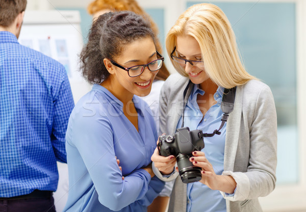 Deux femmes regarder appareil photo numérique bureau affaires photographie [[stock_photo]] © dolgachov