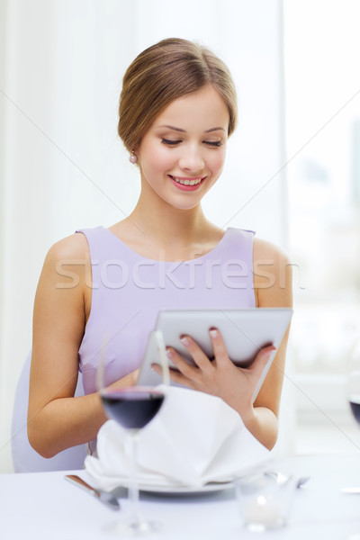 smiling woman with tablet pc computer at resturant Stock photo © dolgachov