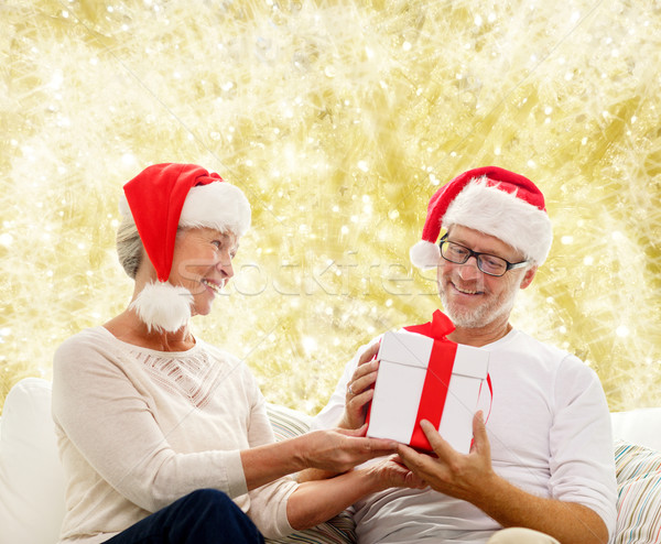 happy senior couple in santa hats with gift box Stock photo © dolgachov