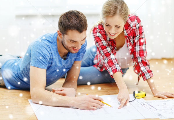 Stock photo: smiling couple with  blueprint at home