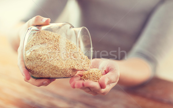 close up of female emptying jar with quinoa Stock photo © dolgachov