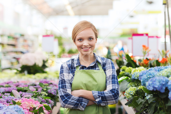 Stock photo: happy woman with flowers in greenhouse