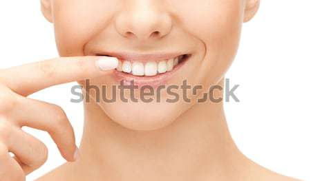 beautiful woman pointing to teeth Stock photo © dolgachov