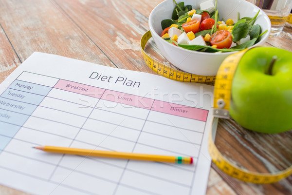 close up of diet plan and food on table Stock photo © dolgachov