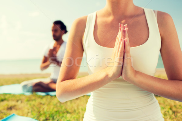 Stock photo: close up of couple making yoga exercises outdoors