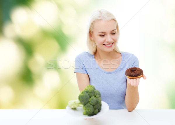 [[stock_photo]]: Femme · souriante · brocoli · donut · régime · alimentaire