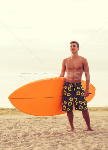 Mosolyog fiatalember szörfdeszka tengerpart tenger nyári vakáció Stock fotó © dolgachov
