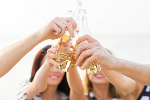close up of friends clinking bottles with drinks Stock photo © dolgachov