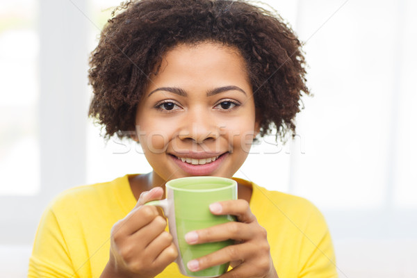 happy african american woman drinking from tea cup Stock photo © dolgachov