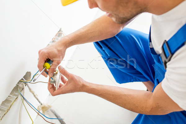 close up of hands with screwdriver fixing socket Stock photo © dolgachov