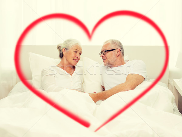 happy senior coupler lying in bad at home Stock photo © dolgachov