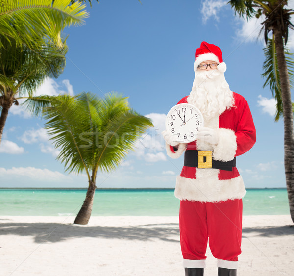 man in costume of santa claus with clock Stock photo © dolgachov