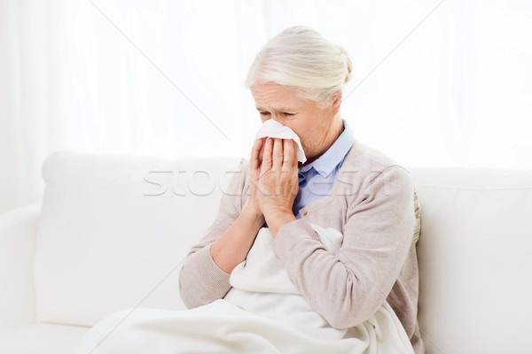 Bolnav senior femeie suflat nasul hârtie şerveţel Imagine de stoc © dolgachov