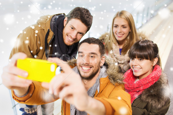 happy friends with smartphone on skating rink Stock photo © dolgachov