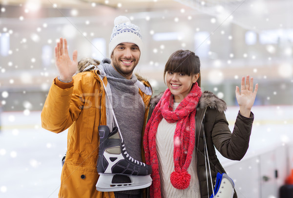 Stock photo: happy couple with ice-skates on skating rink