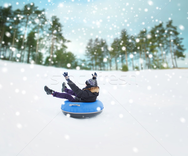 happy young man sliding down on snow tube Stock photo © dolgachov
