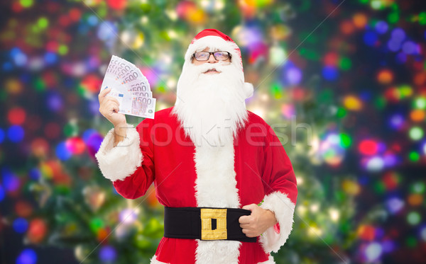 man in costume of santa claus with euro money Stock photo © dolgachov