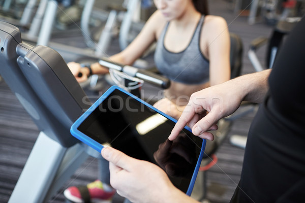 Stock photo: close up of trainer hands with tablet pc in gym