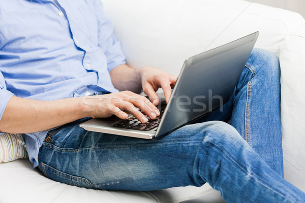 close up of man typing on laptop computer at home Stock photo © dolgachov