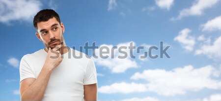 man thinking over blue sky and clouds background Stock photo © dolgachov